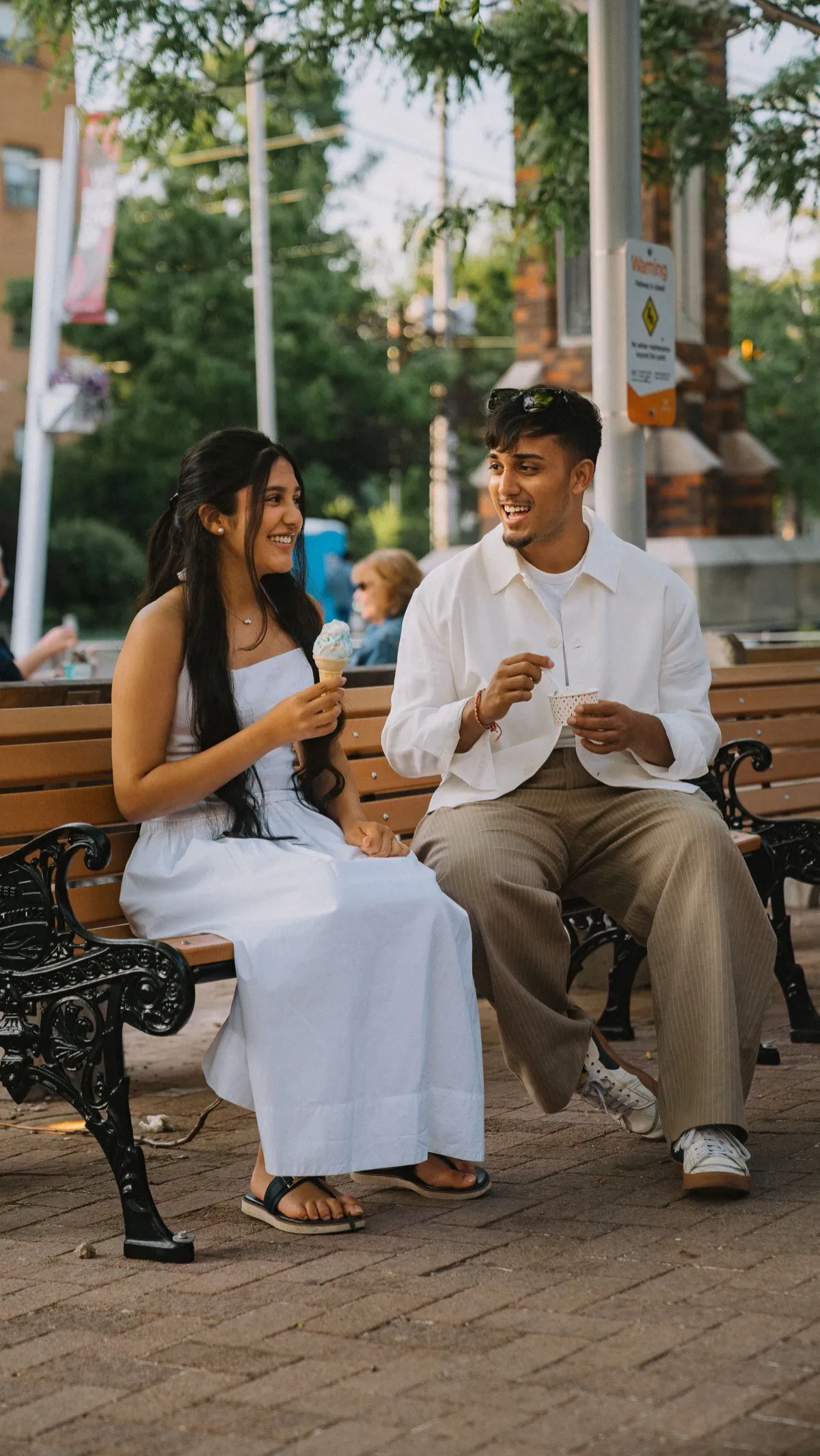 Dev and his sister sharing ice cream on a bench in the Streetsville core